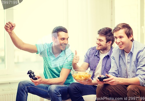 Image of smiling friends playing video games at home