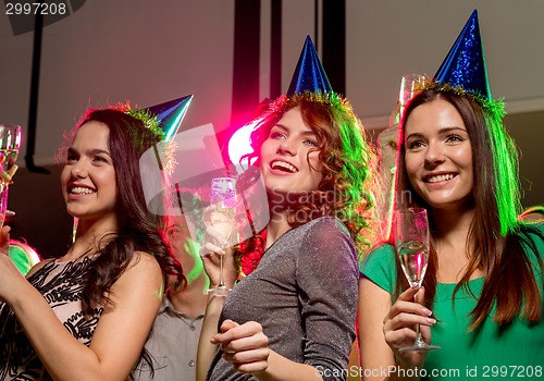 Image of smiling friends with glasses of champagne in club