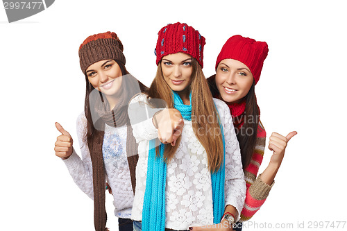 Image of Three girls showing approving gestures pointing at camera