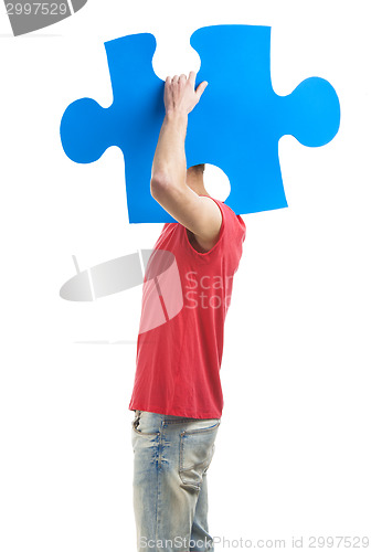 Image of Young man holding a puzzle piece