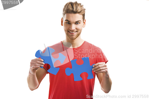 Image of Young man holding a puzzle piece