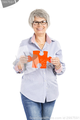 Image of Elderly woman holding a puzzle piece