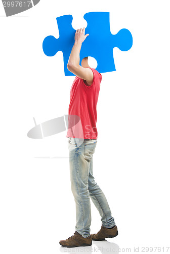 Image of Young man holding a puzzle piece