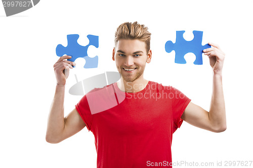 Image of Young man holding a puzzle piece