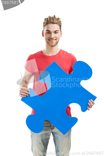 Image of Young man holding a puzzle piece