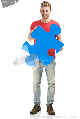 Image of Young man holding a puzzle piece