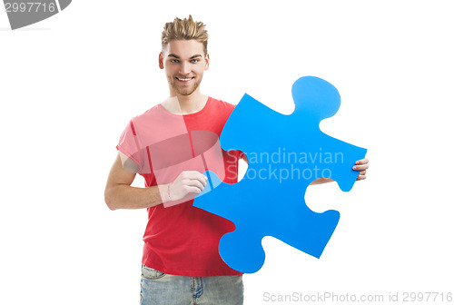 Image of Young man holding a puzzle piece