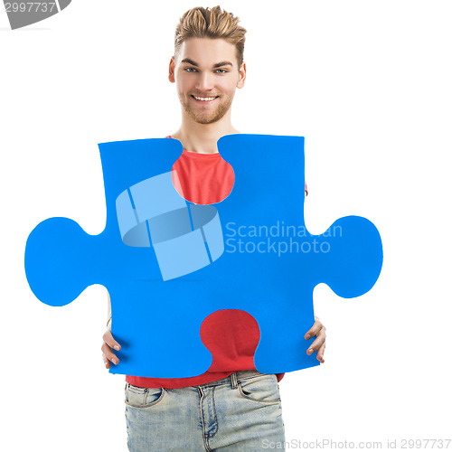 Image of Young man holding a puzzle piece