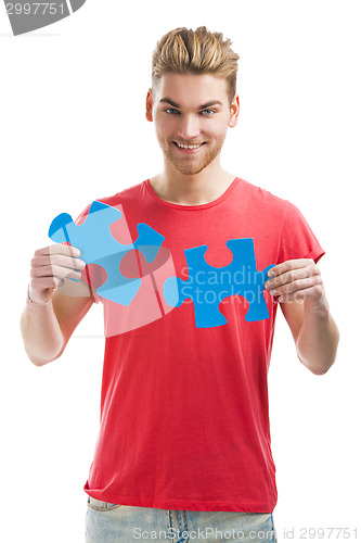 Image of Young man holding a puzzle piece