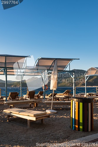Image of Sun loungers with umbrellas on the beach