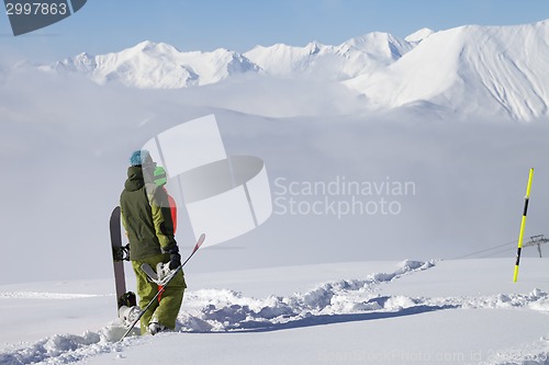 Image of Snowboarders on off-piste slope with new fallen snow