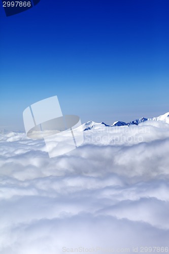 Image of Mountains under clouds and clear blue sky