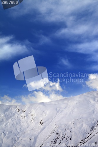 Image of Off-piste slope and blue sky with clouds