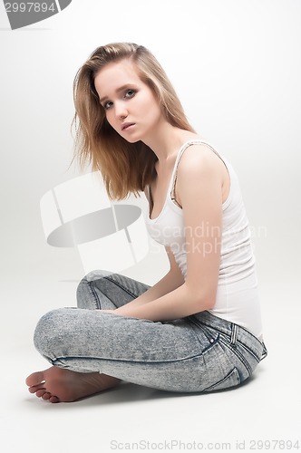 Image of Attractive sad woman on floor