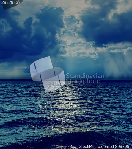 Image of dramatic sky with clouds over dark sea