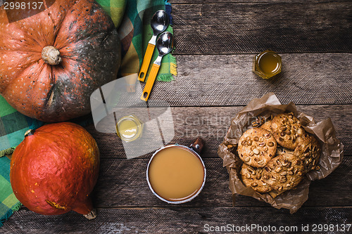 Image of Pumpkins, soup, honey and cookies with nuts on wood
