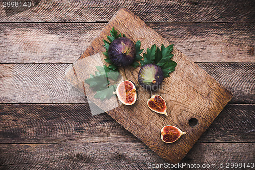 Image of Figs on chopping board and wooden table