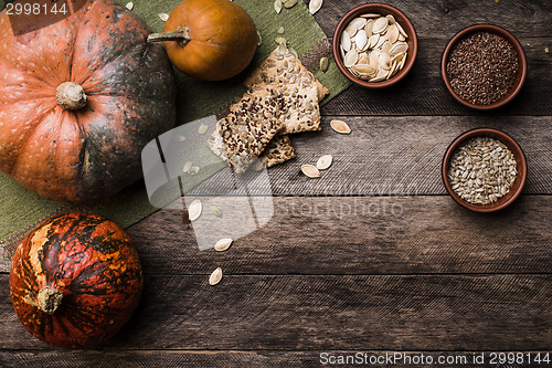 Image of Rustic style pumpkins with seeds and cookies on wooden table