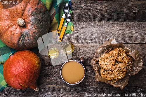 Image of Rustic style pumpkins, soup, honey and cookies with nuts on wood