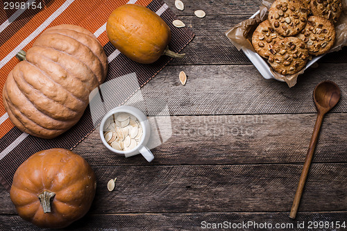 Image of Rustic style pumpkins, seeds and cookies with nuts on wooden tab