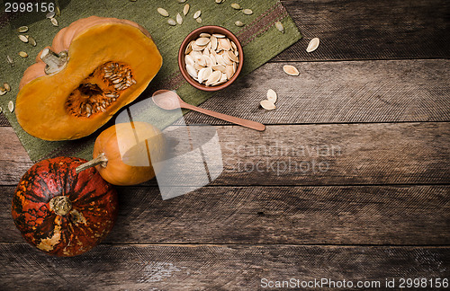 Image of Rustic style pumpkins with seeds on green napkin and wood 
