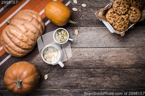 Image of Rustic style pumpkins, seeds and cookies with nuts on table