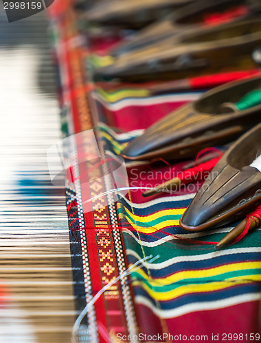 Image of Weaving shuttles and colorful textile 