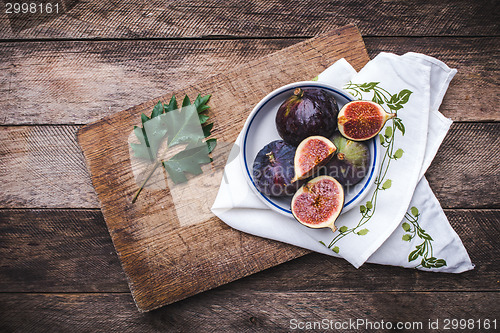 Image of Figs in flat dish on choppingboard and napkin in rustic style