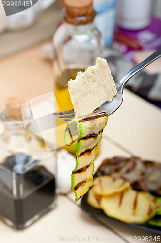 Image of grilled zucchini courgette with cracker on a fork