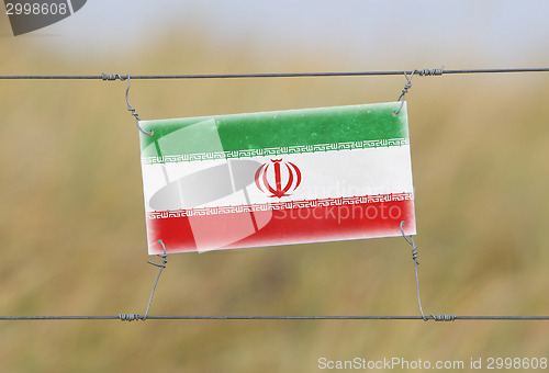 Image of Border fence - Old plastic sign with a flag