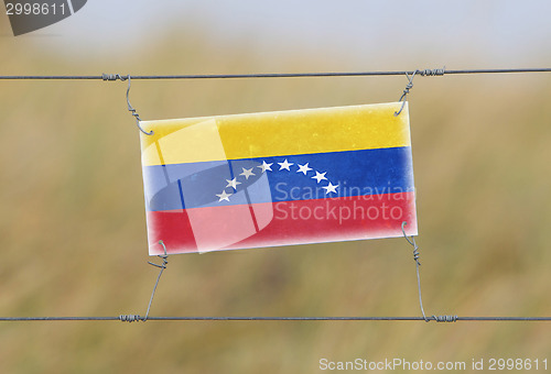 Image of Border fence - Old plastic sign with a flag