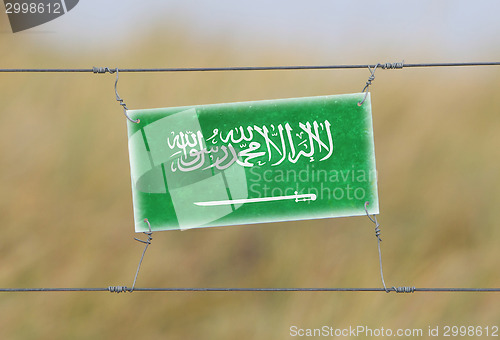 Image of Border fence - Old plastic sign with a flag