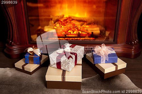 Image of Christmas gift boxes near fireplace