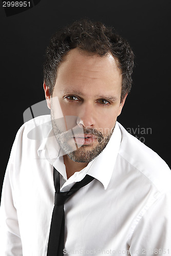 Image of Attractive man with white shirt and black tie looks into the cam