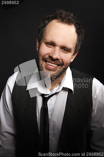 Image of Attractive man with dark jacket smiles into the camera