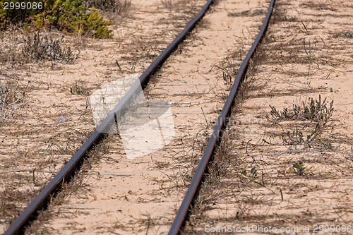 Image of Steel Railroad Tracks on Sand Beach