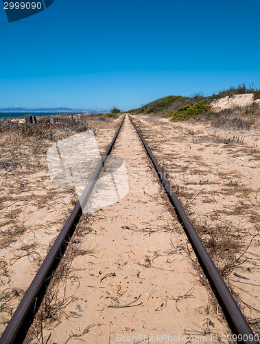 Image of Steel Railroad Tracks on Sand Beach