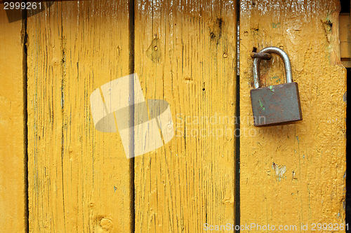 Image of padlock on yellow wooden door