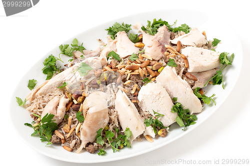 Image of Lebanese dish of chicken and spiced rice with nuts and parsley