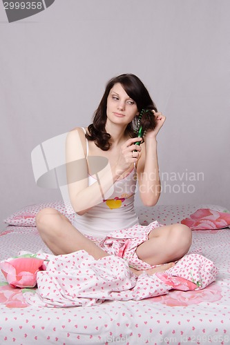 Image of Girl combing her hair in the morning