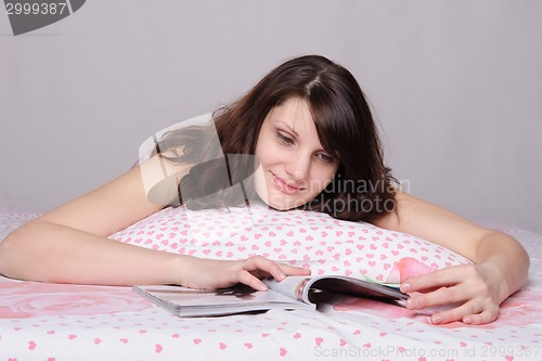 Image of girl with smile reading a magazine article