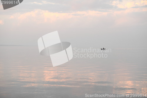 Image of silhouette of a fishing boat on the horizon