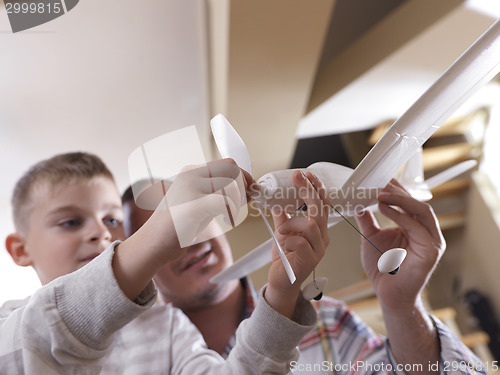 Image of father and son assembling airplane toy