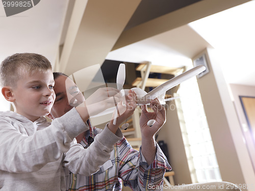 Image of father and son assembling airplane toy