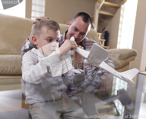 Image of father and son assembling airplane toy