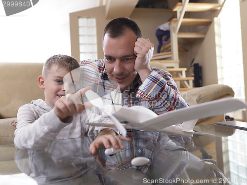 Image of father and son assembling airplane toy