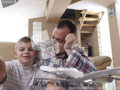 Image of father and son assembling airplane toy