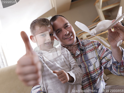 Image of father and son assembling airplane toy