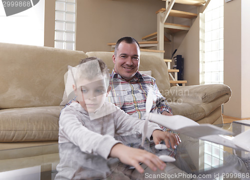 Image of father and son assembling airplane toy