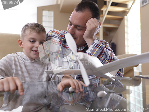 Image of father and son assembling airplane toy